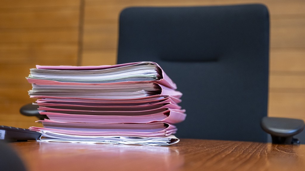 Symbolbild. Ein Aktenstapel liegt zu Protessbeginn auf dem Richtertisch im Verhandlungssaal.