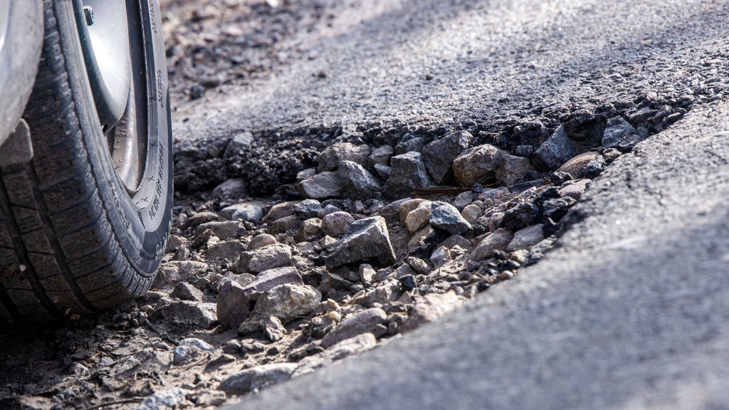 Ein Auto fährt durch ein Schlagloch.