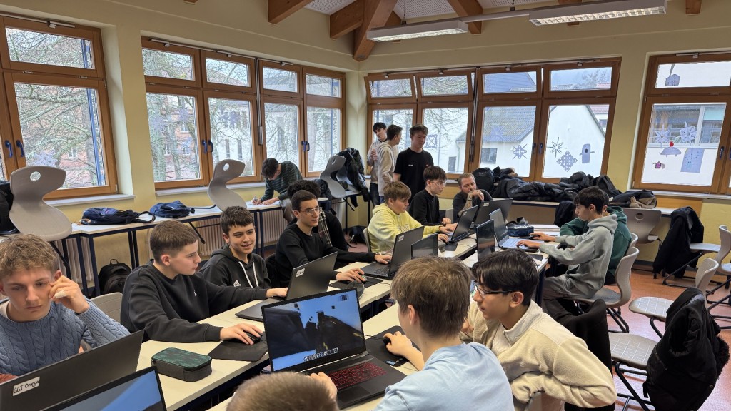 Schüler sitzen in ihrem Klassenzimmer vor Laptops