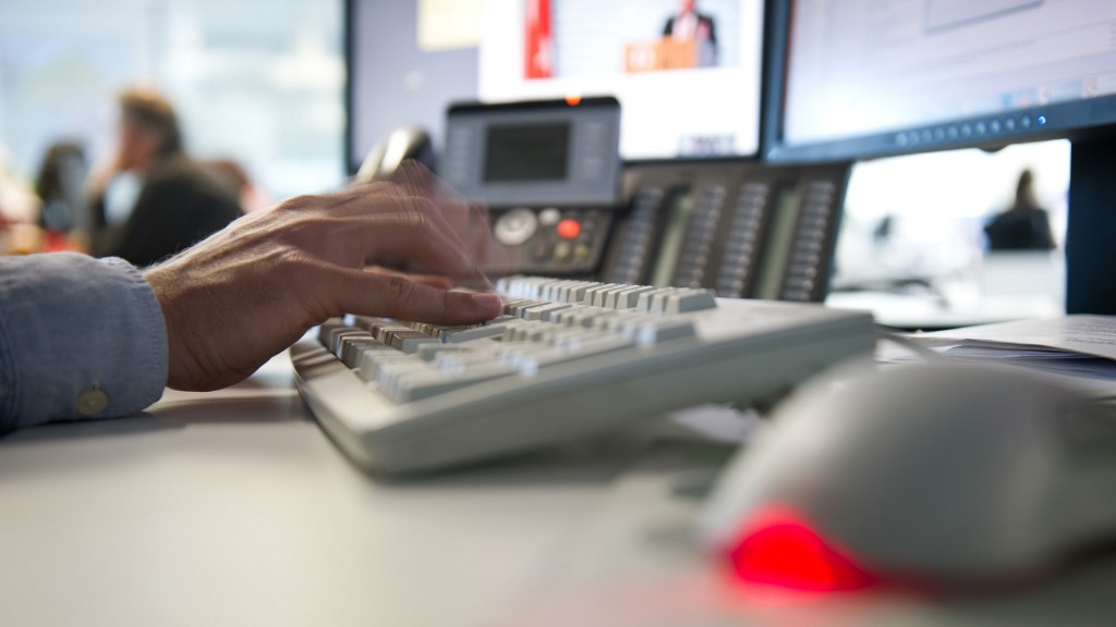 Ein Mann tippt einem Büro auf einer Tastatur
