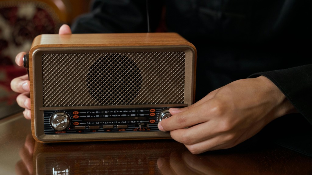 Eine Hand dreht am Lautstärke-Regler eines Radios