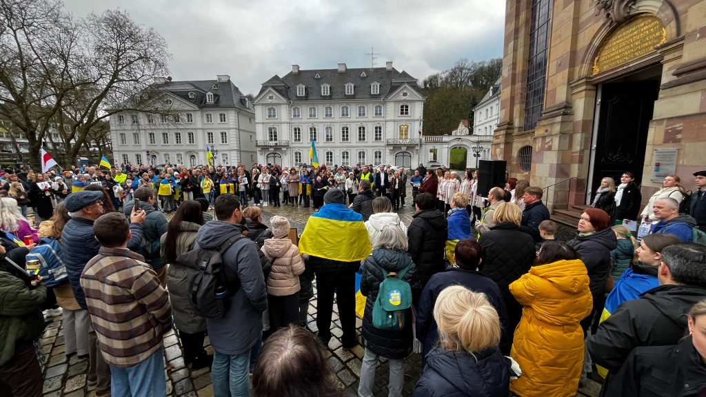 Teilnehmer einer Gedenkveranstaltung zum vierten Jahrestag des Ukraine-Krieges vor der Ludwigskirche in Saarbrücken.