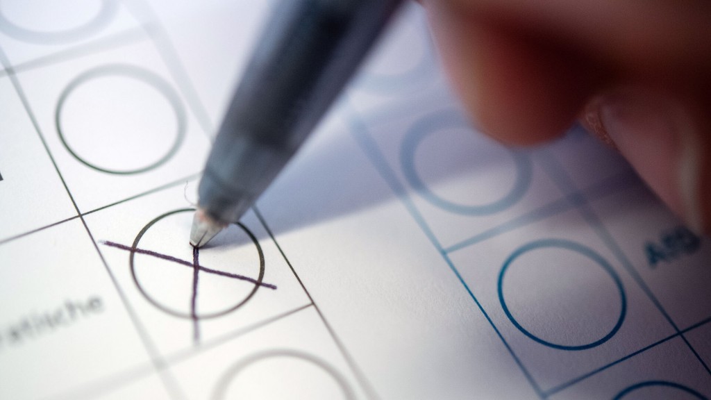 Foto: Eine Frau macht ein Kreuz auf einem Wahlzettel