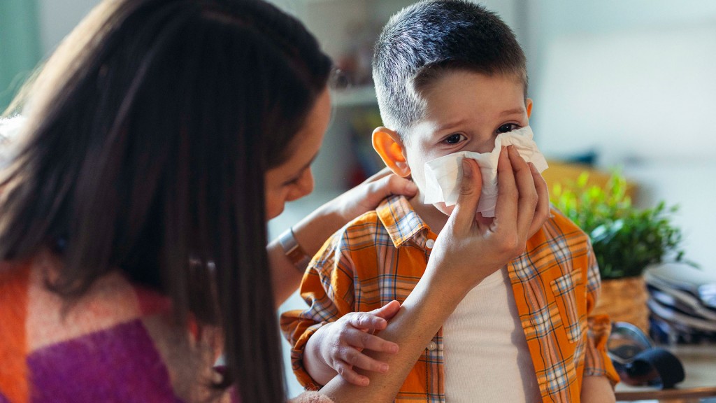 Eine Frau hält einem Kind ein Taschentuch vor die Nase