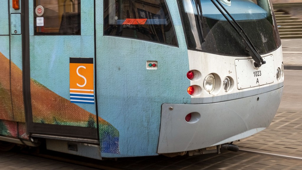 Das Logo der Straßenbahn auf einem vorbeifahrenden Schienenfahrzeug