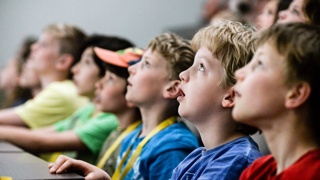 Kinder sitzen staunend im Hörsaal