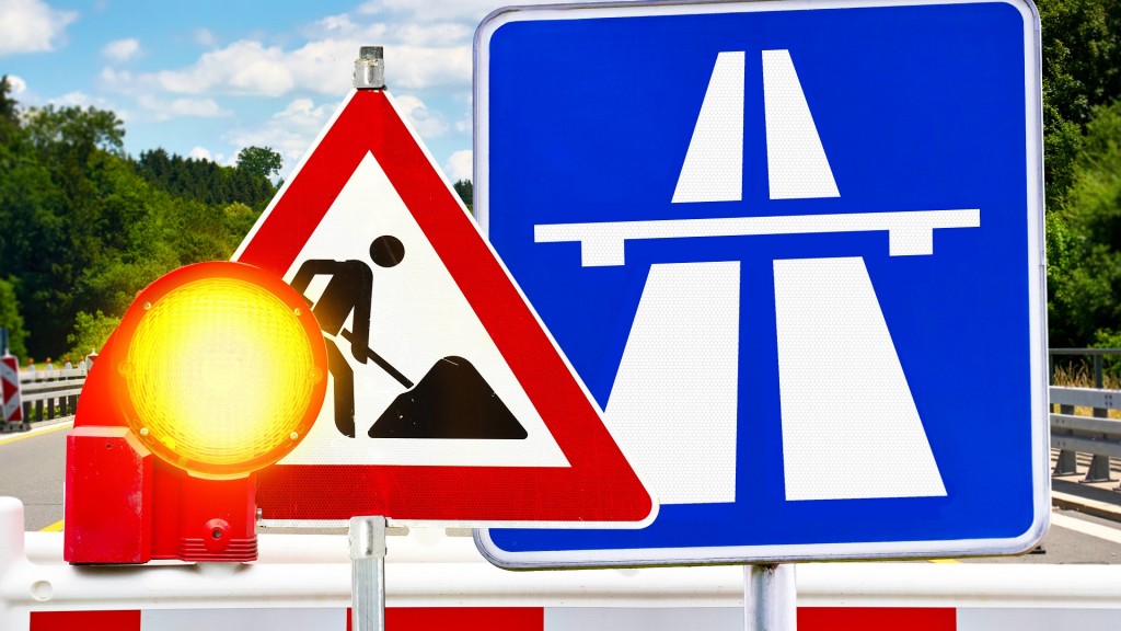 Fotomontage. Ein Autobahn- und Baustellenschild mit Warnlampe zeigt den Hinweis auf Bauarbeiten.