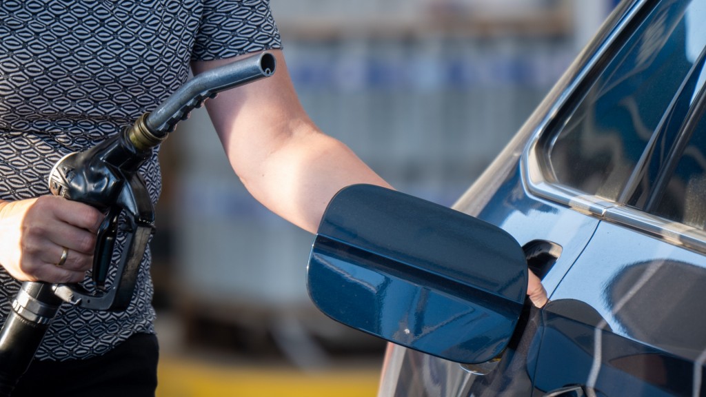 Eine Frau betankt ein Auto an einer Tankstelle 