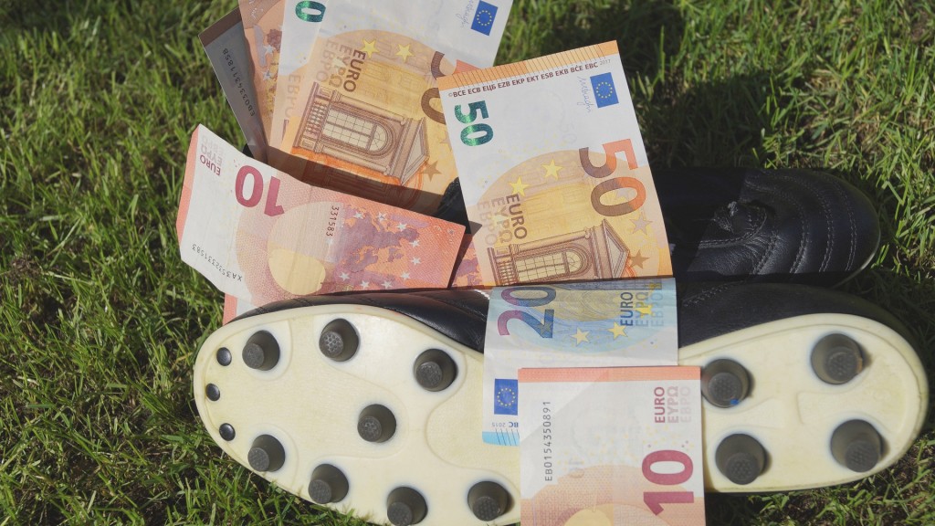 Foto: Symbolbild. Fussballschuh mit Euros auf einem Rasen.