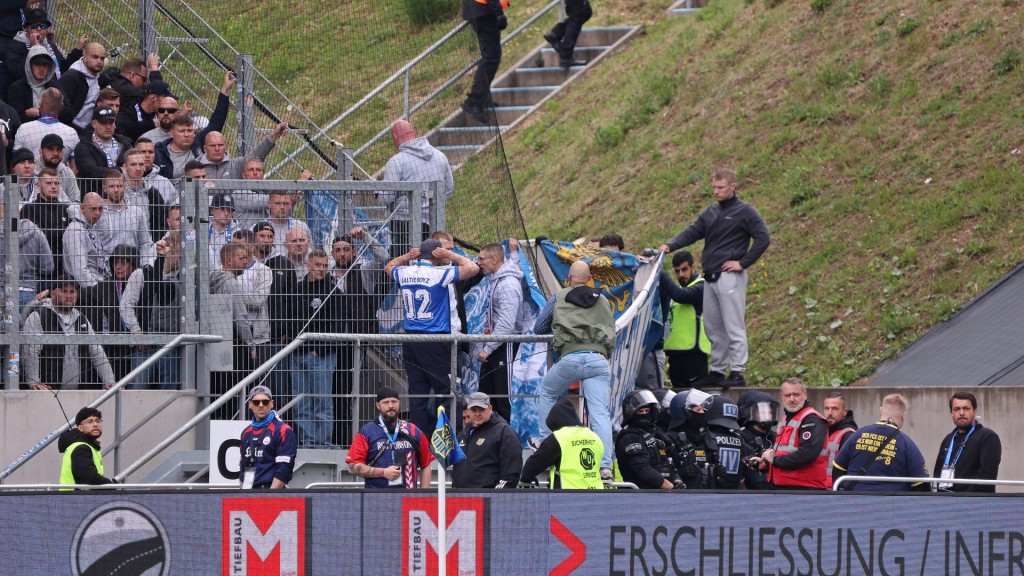 Foto: Fans schirmen nach einem schweren Sturz im Ludwigspark mit Bannern die Unfallstelle ab