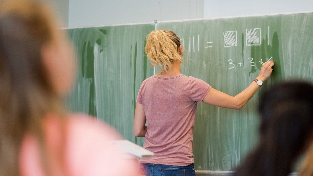 Foto: Eine junge Grundschullehrerin schreibt etwas an die Tafel
