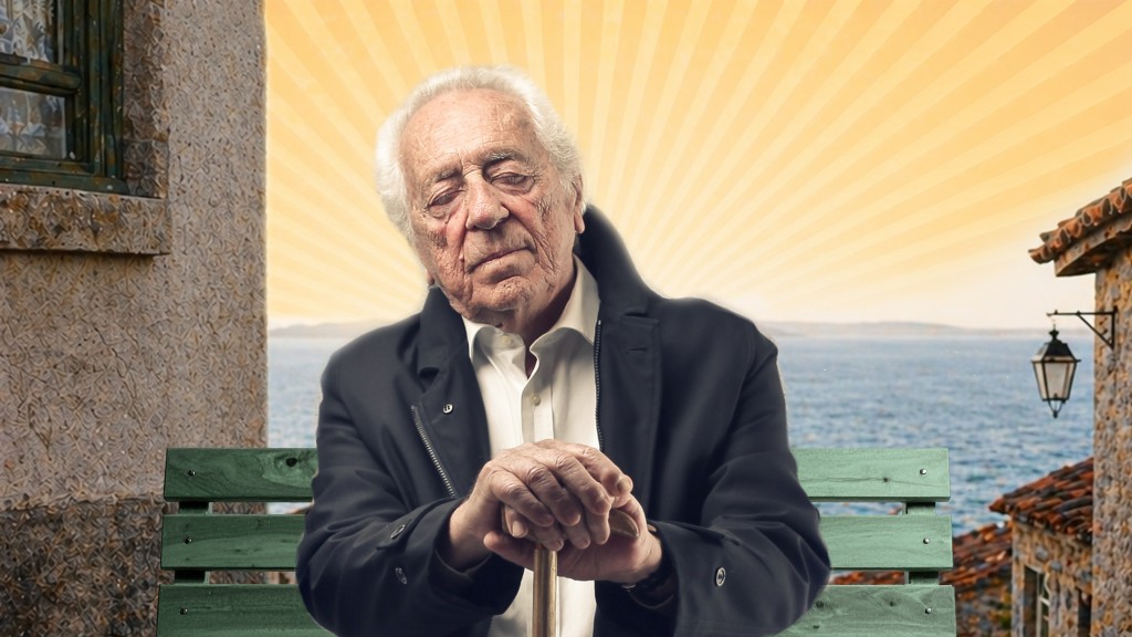 Ein alter Mann, der auf einer Bank sitzt. Er hat die Augen geschlossen, als würde er schlafen, und die Hände auf einen Gehstock vor sich abgestützt. Im Hintergrund eine mediterrane Stadt und das Meer.