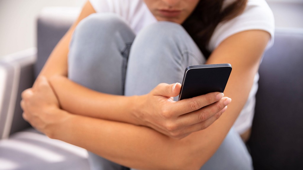 Eine Frau, die nachdenklich ihr Smartphone benutzt