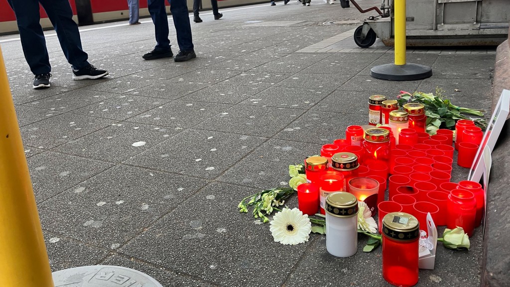 Foto: Blumen und Grablichter zum Gedenken an den getöteten Zugbegleiter liegen an einem Bahnsteig