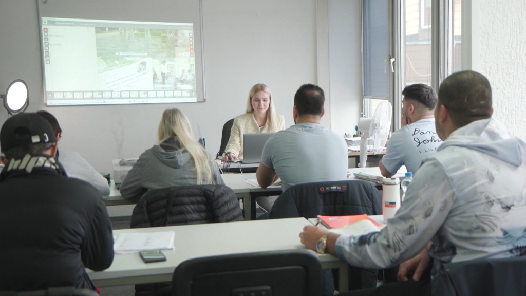 Menschen die in einem Klassenraum unterrichtet werden