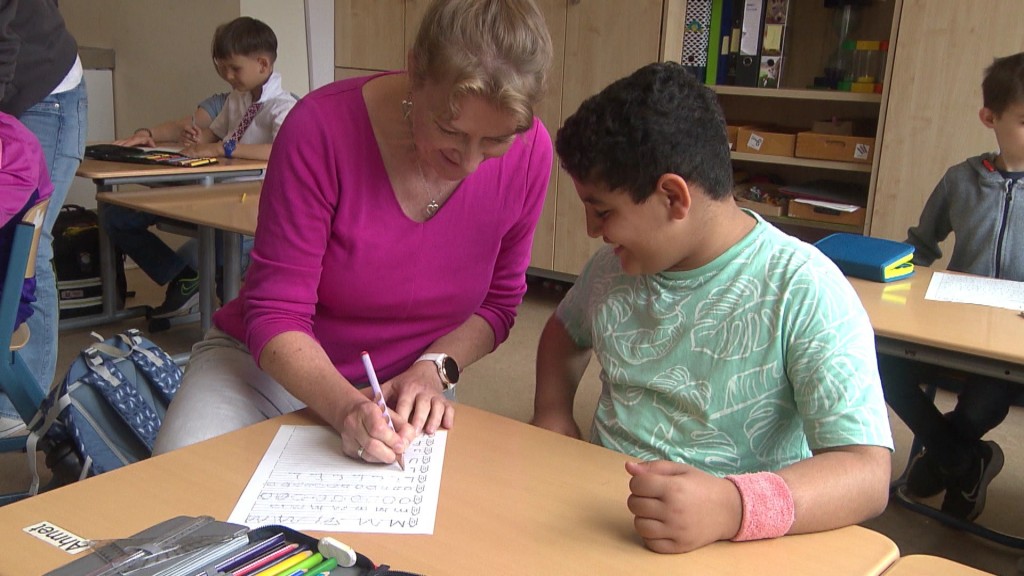 Ein Schüler und eine Lehrerin an einem Tisch
