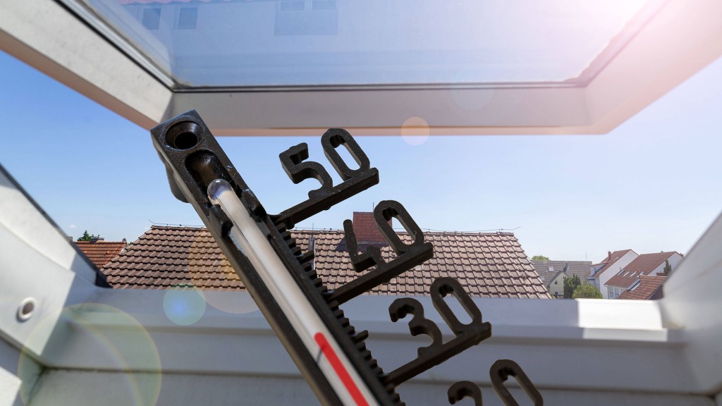 Ein Thermometer vor einem Dachfenster zeigt heiße Raumtemperatur an