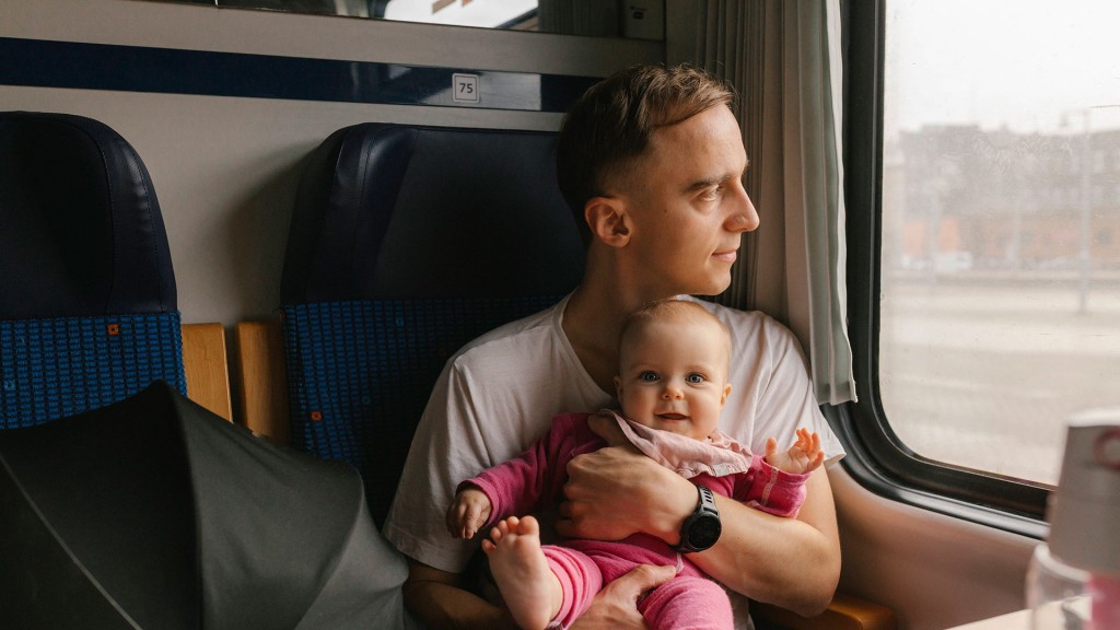 Foto: Vater mit Baby im Arm im Zug