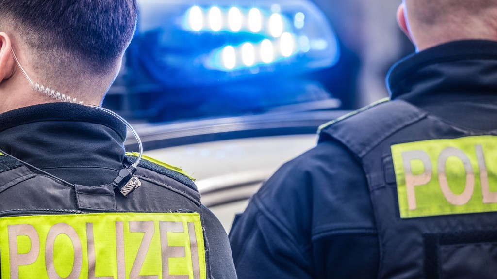 Foto: Polizisten und ein Polizeiwagen mit Blaulicht