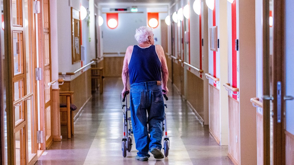 Foto: Ein Bewohner mit seinem Rollator im Flur eines Pflegeheimes