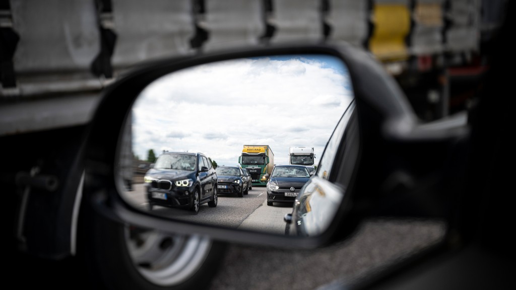Im Rückspiegel eines Autos ist ein Stau auf der Autobahn zu erkennen