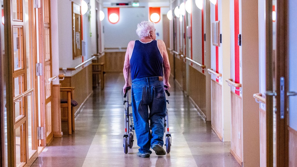 Ein Bewohner mit seinem Rollator im Flur eines Pflegeheimes