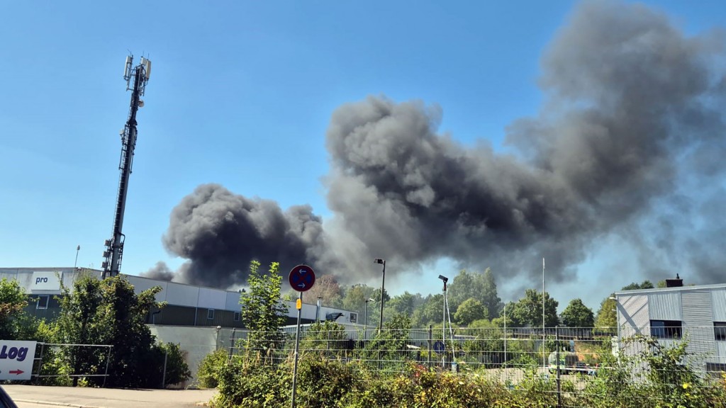 Eine dichte Rauchwolke steht über dem Brand einer Lagerhalle in Neunkirchen