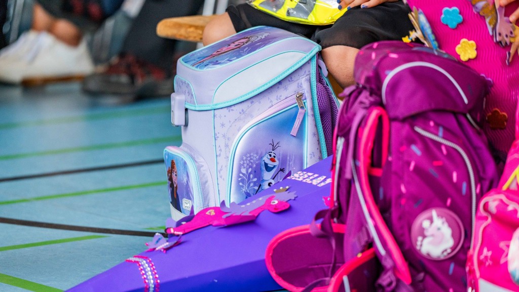 Mehrere Schulranzen stehen auf dem Boden einer Turnhalle