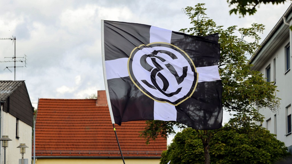 Fans der SV Elversberg schwenken eine Fahne des Vereins