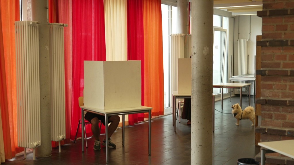 Foto: Menschen in einer Wahlkabine