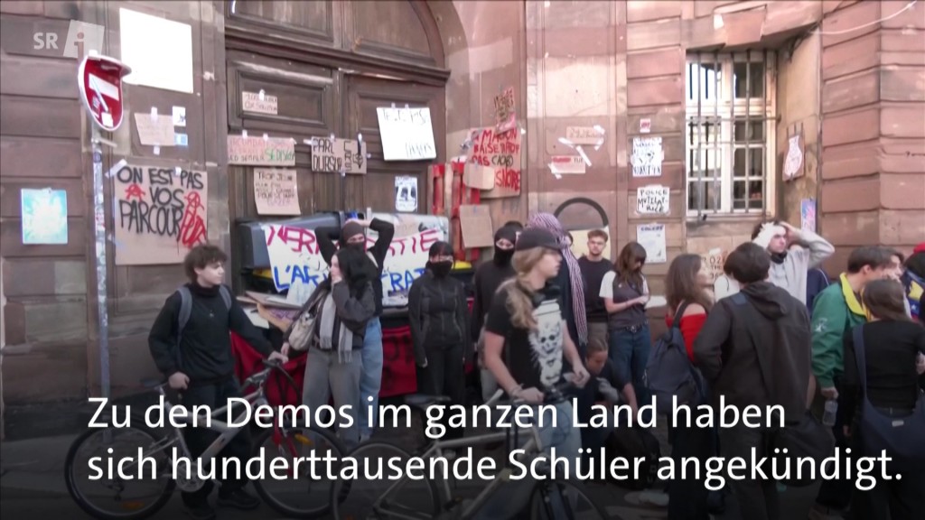 Foto: Schülerinnen und Schüler protestieren mit Schildern vor einem Gebäude