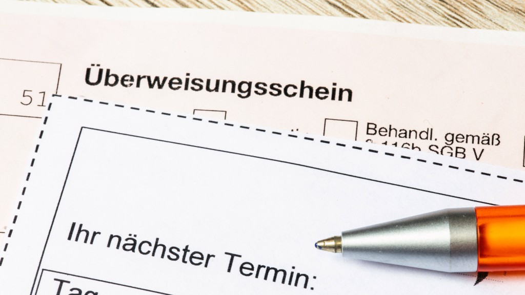 Foto: Nahaufnahme von einem Überweisungsschein für einen Facharzt und einem Terminzettel