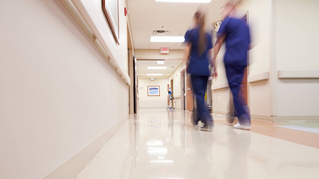 Pflegekräfte gehen einen Krankenhausflur entlang 