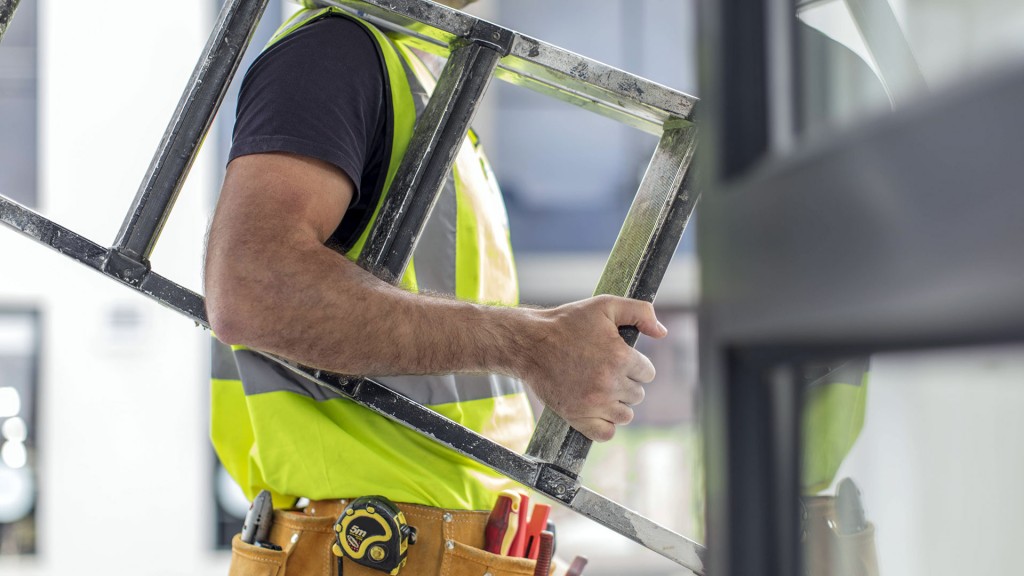 Foto: Symbolbild: ein Handwerker mit Werkzeuggürtel und einer Leiter