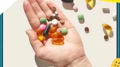 Hand hält verschiedene Multivitamine und Nahrungsergänzungsmittel